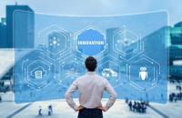 Businessman standing with hands on hips in front of a virtual screen with the word “innovation.”
