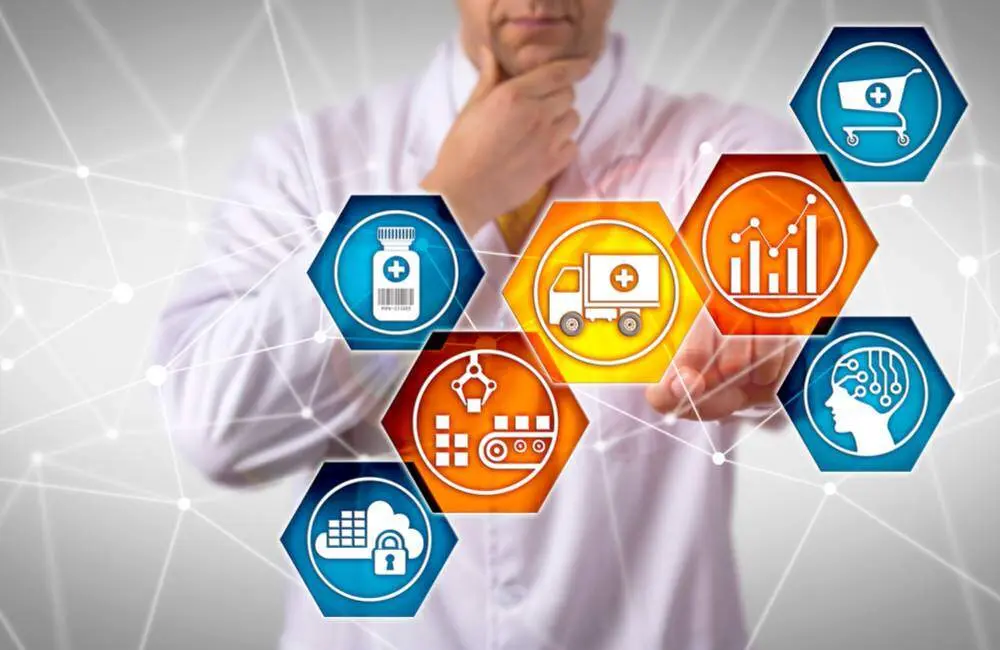 A healthcare professional wearing a labcoat points to a transparent screen of medicine and data related icons.