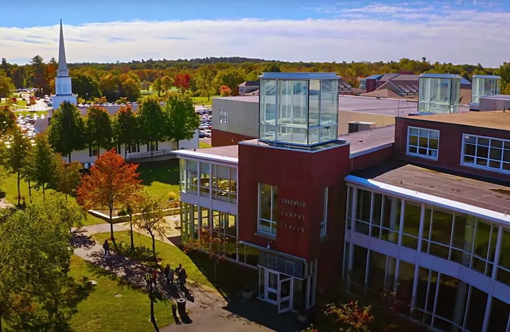 A landscape shot of the Merrimack College campus against a blue sky in autumn.