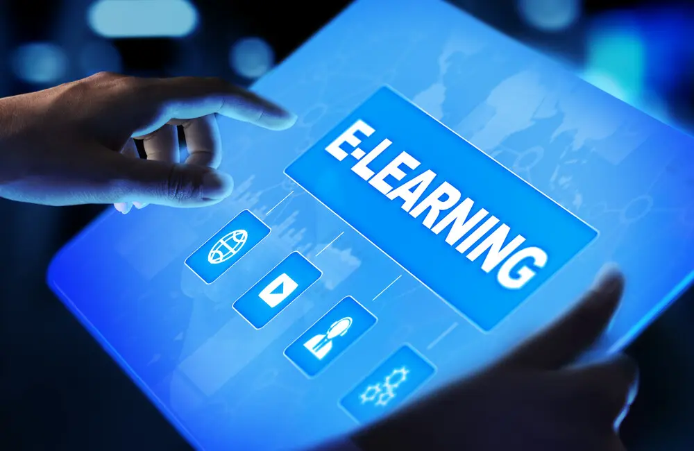 A closeup of hands holding a tablet that says "E-Learning."