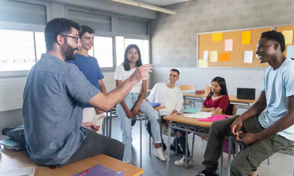 A professor speaks to a group of adult students in a classroom.